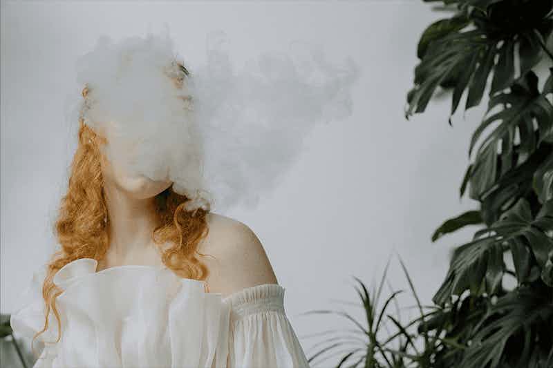 women blowing vapor cloud